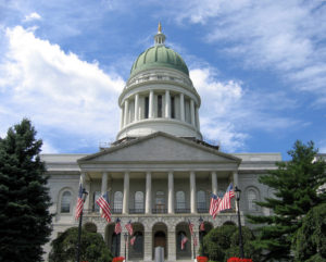 Maine State Capitol building with dome and American flags in front