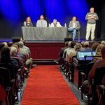photo of an auditorium with four panelists sitting behind a table on a stage and an audience for a discussion on From Treaties to Today.